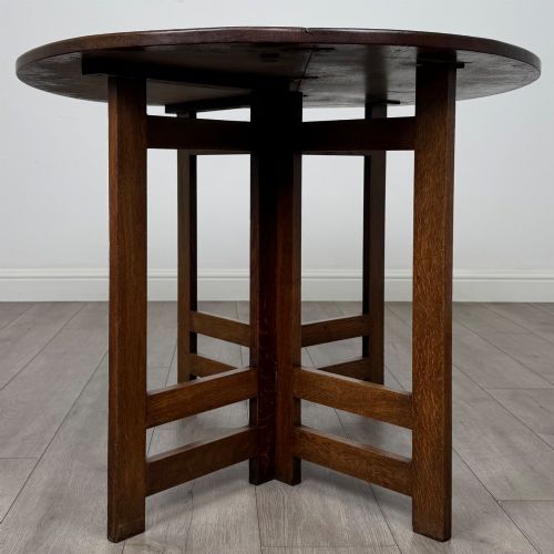 fig 3. An early 20th-century Arts and Crafts solid oak gateleg table featuring drop leaves and a geometric trestle base.