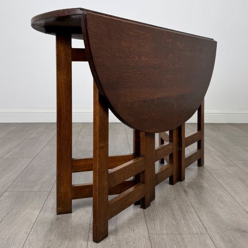 fig 4. An early 20th-century Arts and Crafts solid oak gateleg table featuring drop leaves and a geometric trestle base.