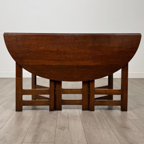 fig 5. An early 20th-century Arts and Crafts solid oak gateleg table featuring drop leaves and a geometric trestle base.