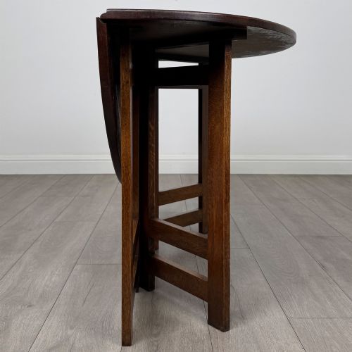 fig 7. An early 20th-century Arts and Crafts solid oak gateleg table featuring drop leaves and a geometric trestle base.