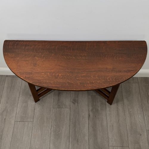fig 9. An early 20th-century Arts and Crafts solid oak gateleg table featuring drop leaves and a geometric trestle base.