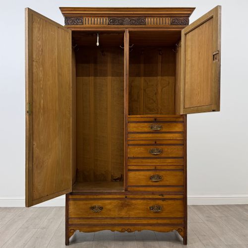 fig 1. A 19th-century ash compactum wardrobe featuring a full-length mirrored door on the left and a carved cupboard with four drawers on the right above a long base drawer.