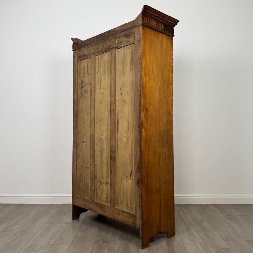fig 6. A 19th-century ash compactum wardrobe featuring a full-length mirrored door on the left and a carved cupboard with four drawers on the right above a long base drawer.