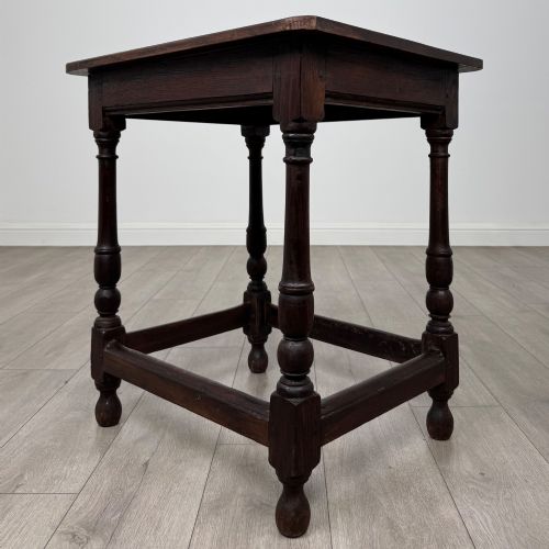fig 5. An antique dark oak side table featuring a rectangular flat top, four turned legs, and a lower four-sided stretcher base.