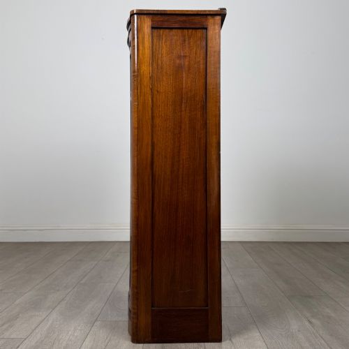 fig 3. A freestanding early 20th-century display cabinet featuring figured walnut veneers, a single glazed door with decorative astragal glazing bars, and internal wooden shelves.