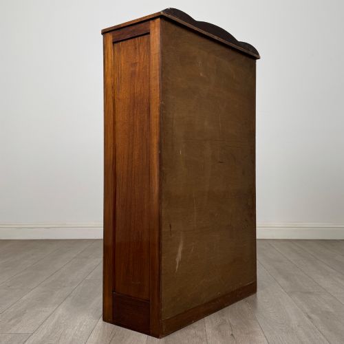 fig 4. A freestanding early 20th-century display cabinet featuring figured walnut veneers, a single glazed door with decorative astragal glazing bars, and internal wooden shelves.