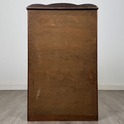 fig 5. A freestanding early 20th-century display cabinet featuring figured walnut veneers, a single glazed door with decorative astragal glazing bars, and internal wooden shelves.