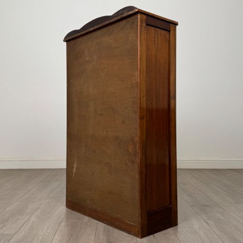 fig 6. A freestanding early 20th-century display cabinet featuring figured walnut veneers, a single glazed door with decorative astragal glazing bars, and internal wooden shelves.