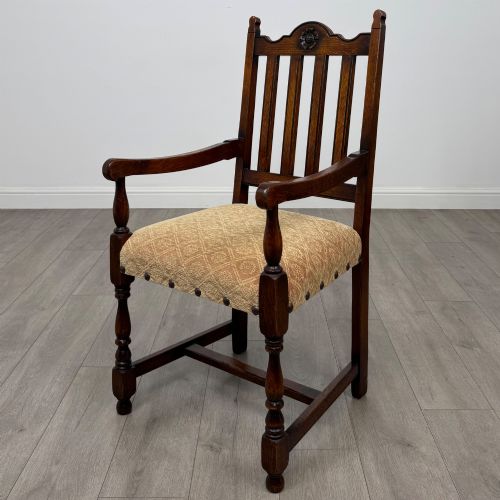 fig 1. A set of six dark oak dining chairs including two armchairs and four side chairs, featuring slat backs with carved crest details and patterned fabric seats.