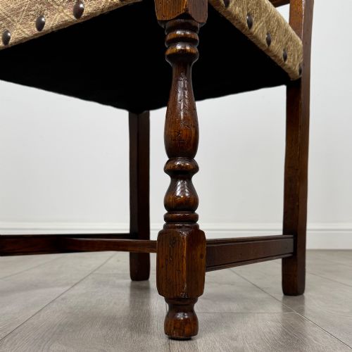 fig 6. A set of six dark oak dining chairs including two armchairs and four side chairs, featuring slat backs with carved crest details and patterned fabric seats.