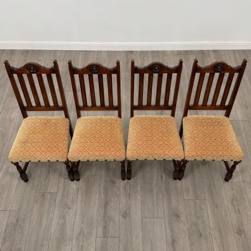 fig 8. A set of six dark oak dining chairs including two armchairs and four side chairs, featuring slat backs with carved crest details and patterned fabric seats.