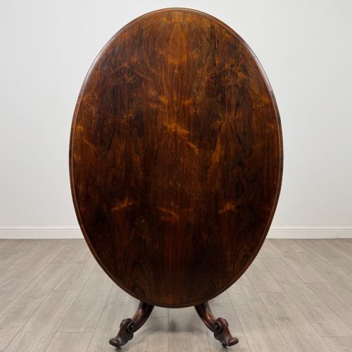 fig 2. A 19th-century Victorian circular rosewood breakfast table with a carved central pedestal column and four scroll legs with brass castors.
