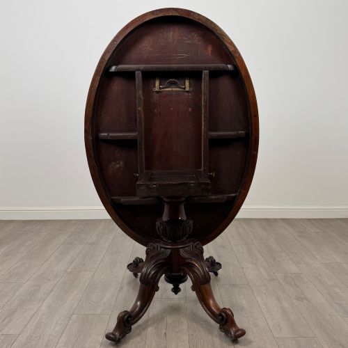 fig 3. A 19th-century Victorian circular rosewood breakfast table with a carved central pedestal column and four scroll legs with brass castors.