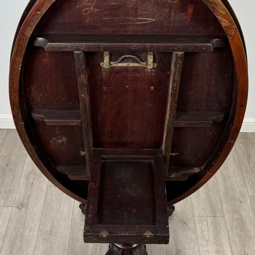 fig 5. A 19th-century Victorian circular rosewood breakfast table with a carved central pedestal column and four scroll legs with brass castors.
