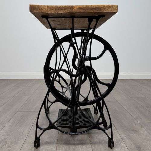 fig 1. An industrial side table featuring a black cast iron Jones treadle sewing machine base topped with a thick rectangular timber board.