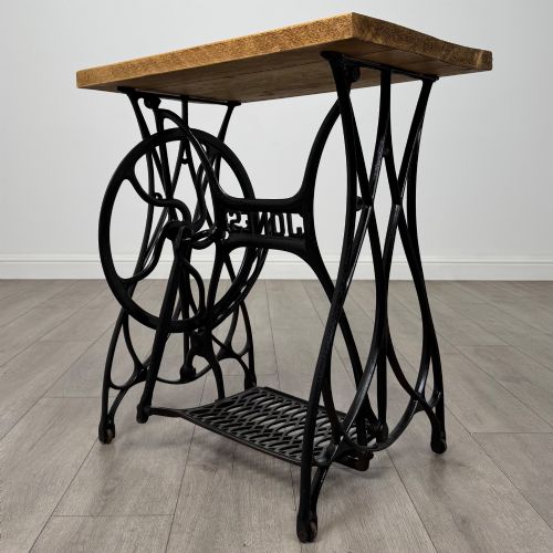 fig 4. An industrial side table featuring a black cast iron Jones treadle sewing machine base topped with a thick rectangular timber board.