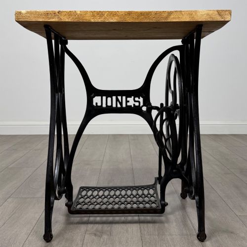 fig 7. An industrial side table featuring a black cast iron Jones treadle sewing machine base topped with a thick rectangular timber board.