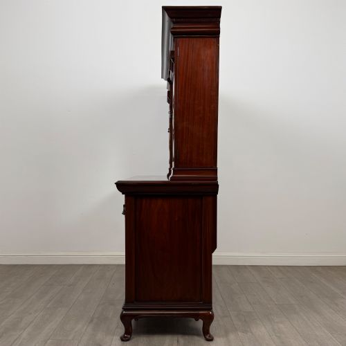 fig 3. An Arts and Crafts dark mahogany sideboard featuring an upper mirrored superstructure flanked by leaded glass cabinet doors above lower drawers and carved cupboards.