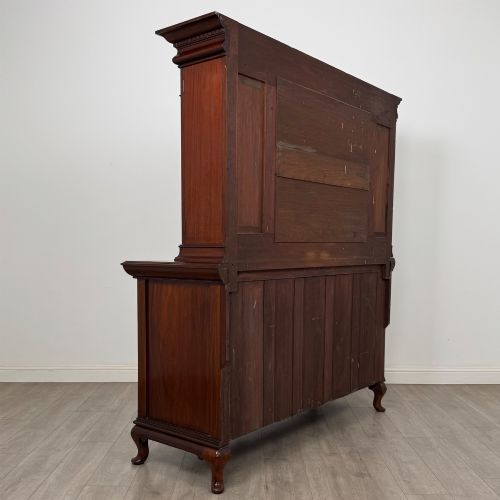 fig 4. An Arts and Crafts dark mahogany sideboard featuring an upper mirrored superstructure flanked by leaded glass cabinet doors above lower drawers and carved cupboards.