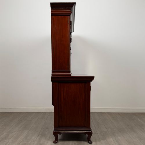 fig 7. An Arts and Crafts dark mahogany sideboard featuring an upper mirrored superstructure flanked by leaded glass cabinet doors above lower drawers and carved cupboards.
