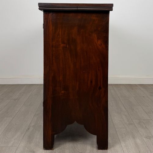 fig 3. A dark oak Gothic Revival sideboard featuring three central drawers with metal drop ring handles, flanked by two carved tracery panel doors with decorative iron latches.