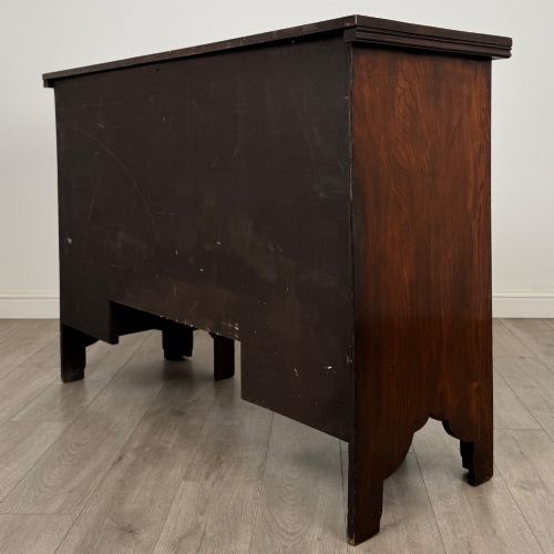 fig 6. A dark oak Gothic Revival sideboard featuring three central drawers with metal drop ring handles, flanked by two carved tracery panel doors with decorative iron latches.