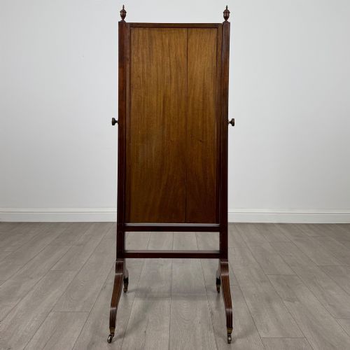 fig 4. An Edwardian mahogany full-length cheval mirror featuring a rectangular tilting glass frame supported by a wooden upright stand with finials and splayed feet on brass castors.