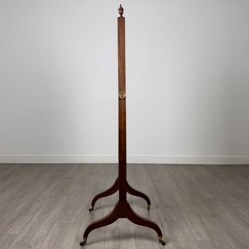 fig 6. An Edwardian mahogany full-length cheval mirror featuring a rectangular tilting glass frame supported by a wooden upright stand with finials and splayed feet on brass castors.