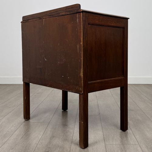 fig 5. A two-drawer golden oak chest of drawers featuring decorative metal drop handles and straight square legs.