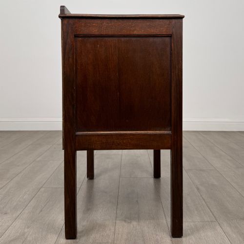 fig 6. A two-drawer golden oak chest of drawers featuring decorative metal drop handles and straight square legs.
