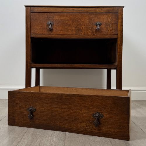 fig 9. A two-drawer golden oak chest of drawers featuring decorative metal drop handles and straight square legs.