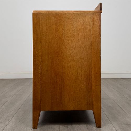 fig 2. An antique golden oak chest of drawers featuring two short drawers above three long drawers with turned wooden knobs.