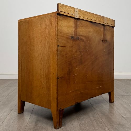 fig 3. An antique golden oak chest of drawers featuring two short drawers above three long drawers with turned wooden knobs.
