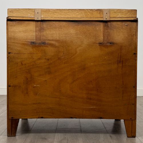 fig 4. An antique golden oak chest of drawers featuring two short drawers above three long drawers with turned wooden knobs.