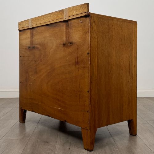 fig 5. An antique golden oak chest of drawers featuring two short drawers above three long drawers with turned wooden knobs.