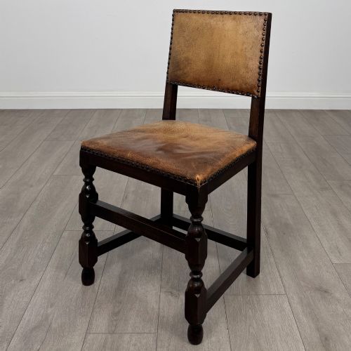 fig 2. A set of six Edwardian dark oak dining chairs with tan studded leather upholstery, comprising two carver armchairs and four side chairs featuring turned legs.