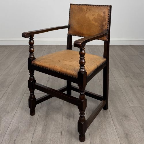 fig 4. A set of six Edwardian dark oak dining chairs with tan studded leather upholstery, comprising two carver armchairs and four side chairs featuring turned legs.