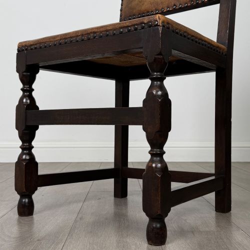 fig 6. A set of six Edwardian dark oak dining chairs with tan studded leather upholstery, comprising two carver armchairs and four side chairs featuring turned legs.