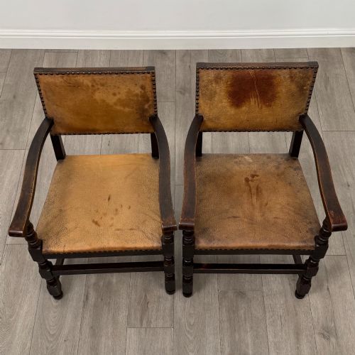 fig 8. A set of six Edwardian dark oak dining chairs with tan studded leather upholstery, comprising two carver armchairs and four side chairs featuring turned legs.
