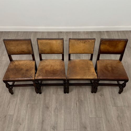 fig 9. A set of six Edwardian dark oak dining chairs with tan studded leather upholstery, comprising two carver armchairs and four side chairs featuring turned legs.