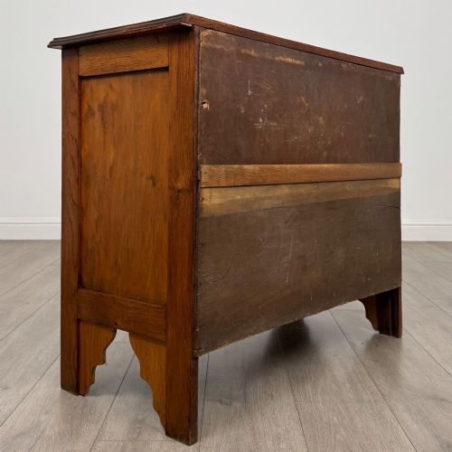 fig 3. An Edwardian warm brown oak chest of drawers featuring two short upper drawers and two long lower drawers with brass drop handles.