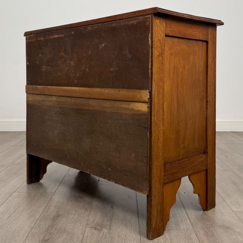 fig 5. An Edwardian warm brown oak chest of drawers featuring two short upper drawers and two long lower drawers with brass drop handles.