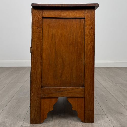 fig 6. An Edwardian warm brown oak chest of drawers featuring two short upper drawers and two long lower drawers with brass drop handles.