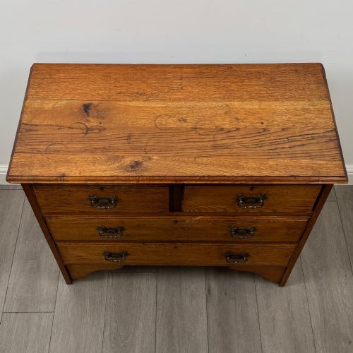 fig 8. An Edwardian warm brown oak chest of drawers featuring two short upper drawers and two long lower drawers with brass drop handles.