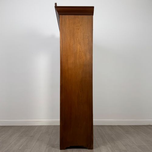 fig 3. An Edwardian walnut wardrobe featuring a central mirrored door flanked by carved timber panels above a single base drawer.