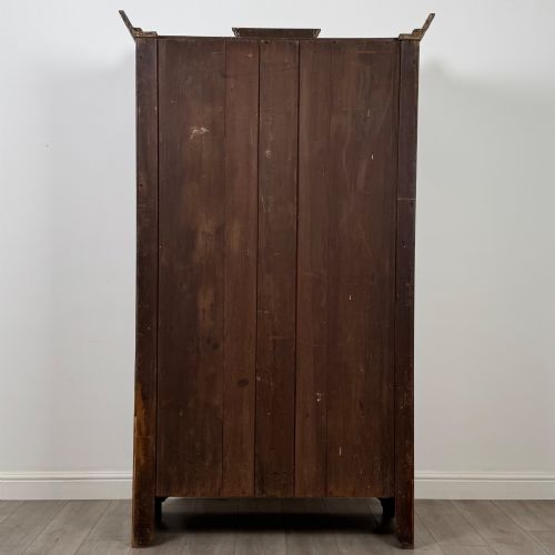 fig 5. An Edwardian walnut wardrobe featuring a central mirrored door flanked by carved timber panels above a single base drawer.