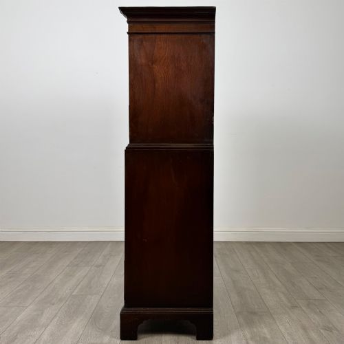 fig 2. A tall 20th-century mahogany serpentine chest of drawers featuring seven graduated drawers with brass handles and bracket feet.