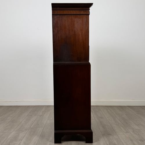 fig 6. A tall 20th-century mahogany serpentine chest of drawers featuring seven graduated drawers with brass handles and bracket feet.