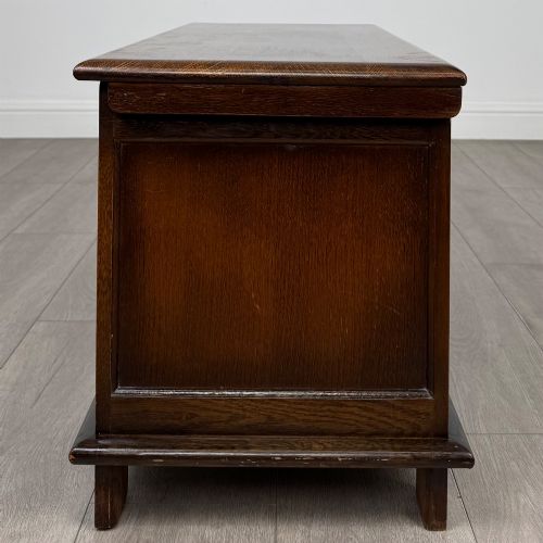 fig 2. A rectangular dark oak blanket box featuring three carved front panels with Gothic arched details and a flat top lid.