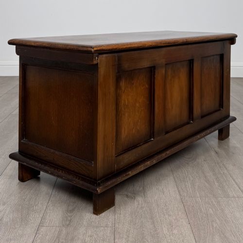 fig 3. A rectangular dark oak blanket box featuring three carved front panels with Gothic arched details and a flat top lid.